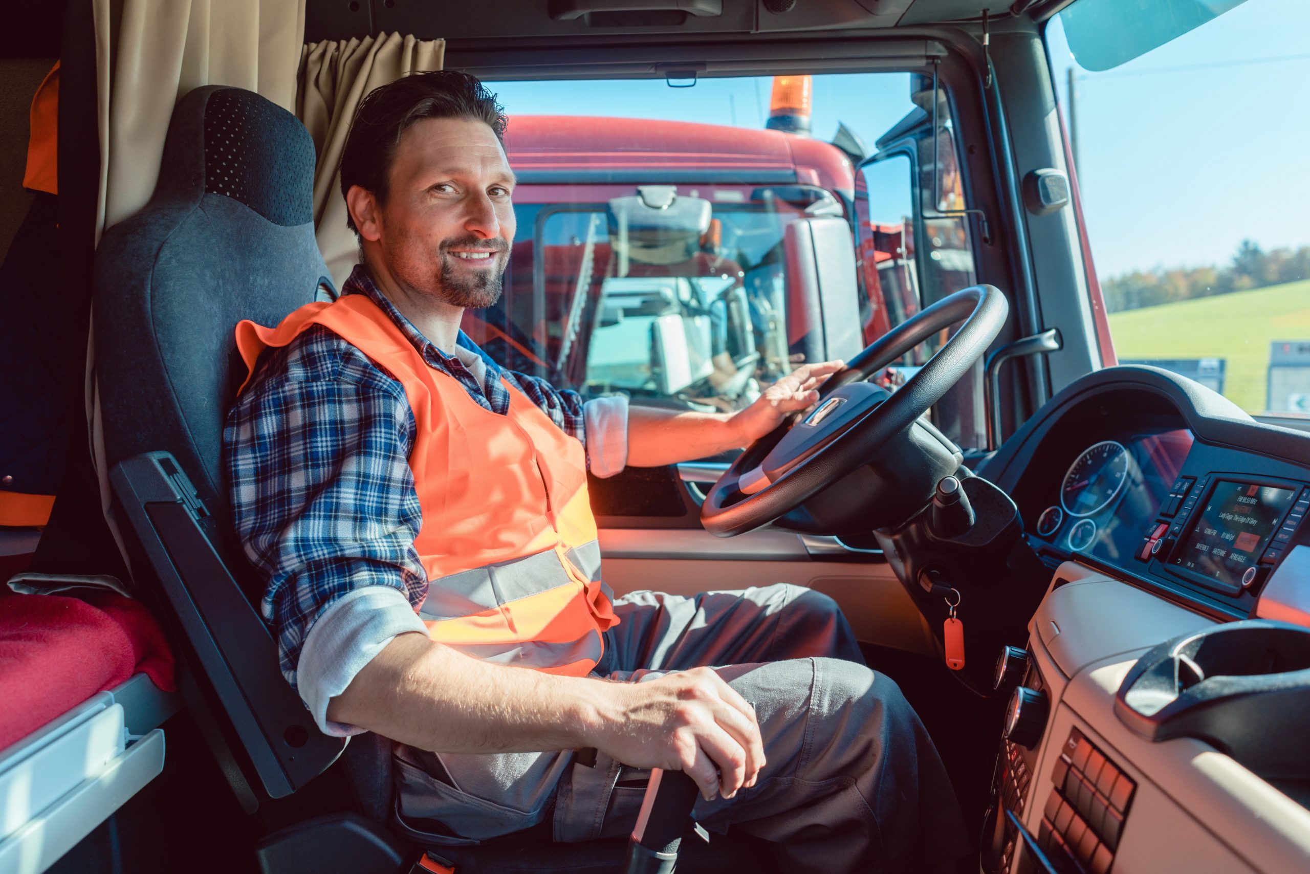 Lorry or truck driver sitting in the cabin of his vehicle driving