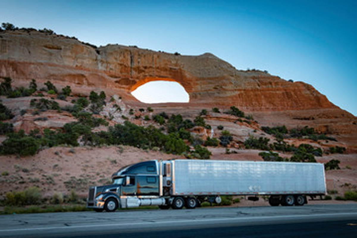 A commercial truck on an El Paso highway in front of a beautiful rock formation